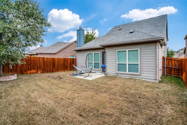 back of house with a patio area and a lawn