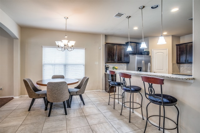 dining space featuring a notable chandelier and light tile patterned floors