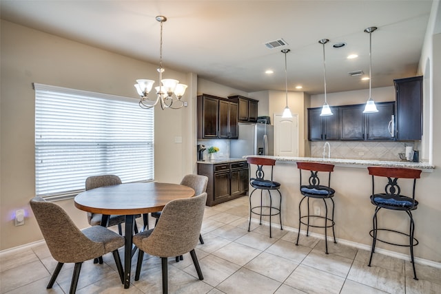 tiled dining space with a notable chandelier and sink