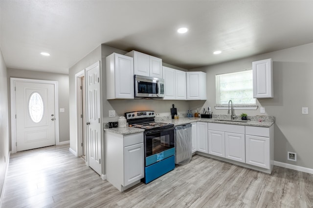 kitchen with white cabinetry, light hardwood / wood-style flooring, stainless steel appliances, and sink