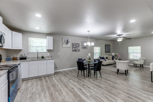 kitchen with light hardwood / wood-style flooring, white cabinets, black / electric stove, and sink