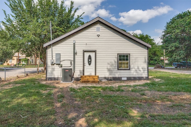 bungalow-style house featuring a front yard and cooling unit