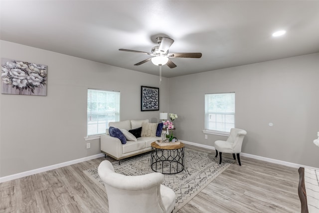 living room featuring a wealth of natural light, light wood-type flooring, and ceiling fan