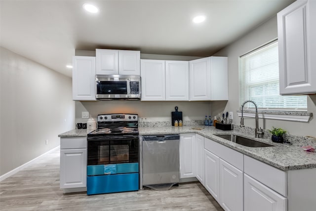 kitchen with sink, appliances with stainless steel finishes, and white cabinetry