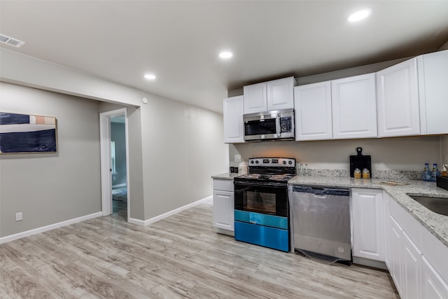 kitchen featuring appliances with stainless steel finishes, white cabinetry, and light wood-type flooring