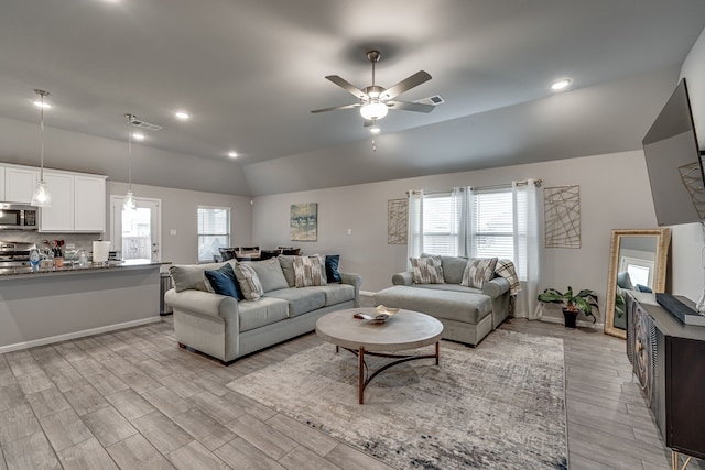 living room featuring ceiling fan, light wood-type flooring, and plenty of natural light