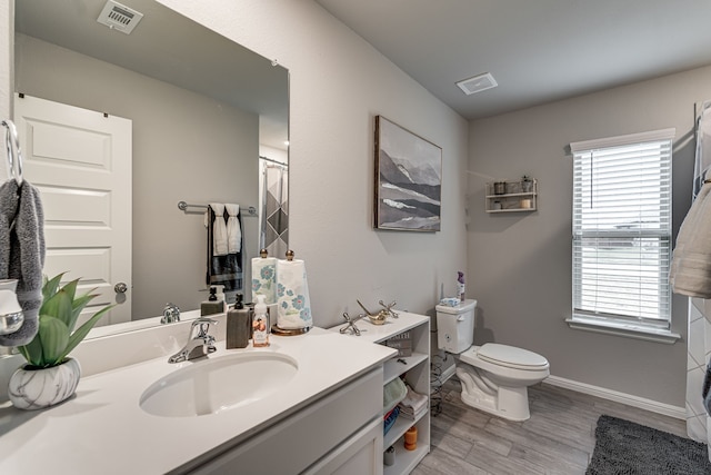 bathroom with vanity, toilet, and hardwood / wood-style floors