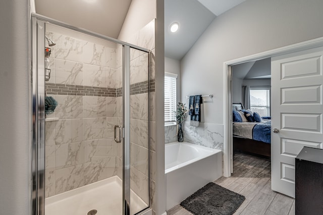 bathroom featuring lofted ceiling, hardwood / wood-style floors, and plus walk in shower