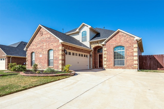 view of property featuring a garage and a front lawn