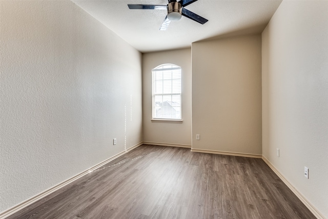 spare room featuring ceiling fan and dark hardwood / wood-style floors