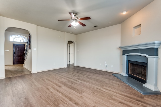 unfurnished living room with ceiling fan and light hardwood / wood-style flooring