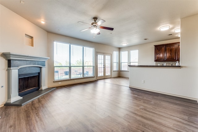 unfurnished living room featuring a textured ceiling, wood-type flooring, and ceiling fan