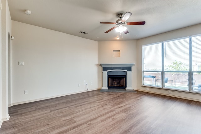 unfurnished living room with a textured ceiling, hardwood / wood-style flooring, and ceiling fan