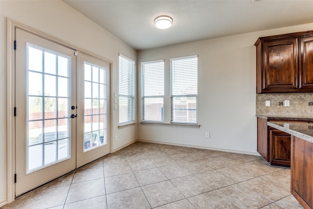 doorway to outside featuring french doors and light tile patterned flooring