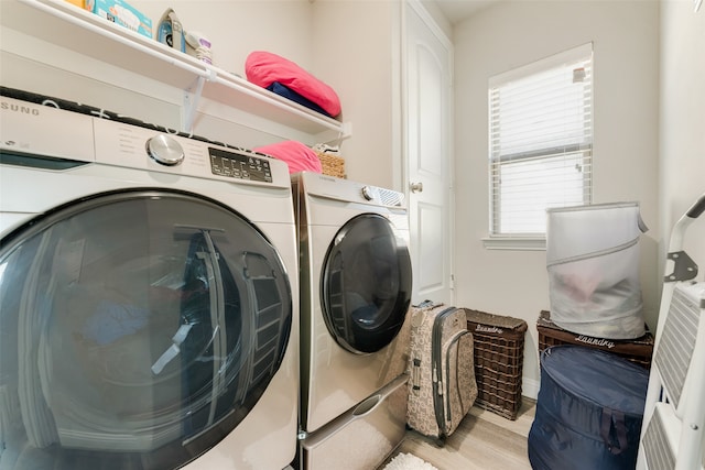 laundry room with independent washer and dryer and light wood-type flooring