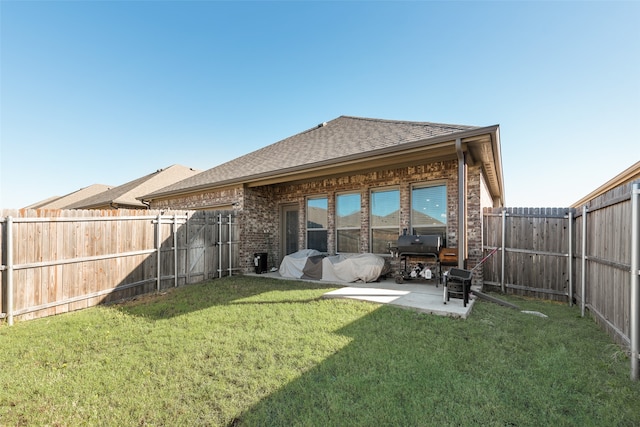 rear view of property featuring a lawn and a patio area