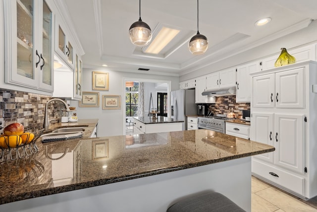 kitchen featuring sink, white cabinetry, hanging light fixtures, and dark stone counters