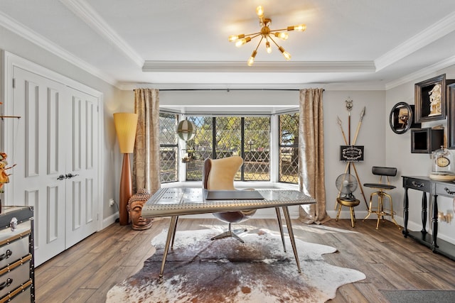 office space with crown molding, a raised ceiling, wood-type flooring, and a chandelier