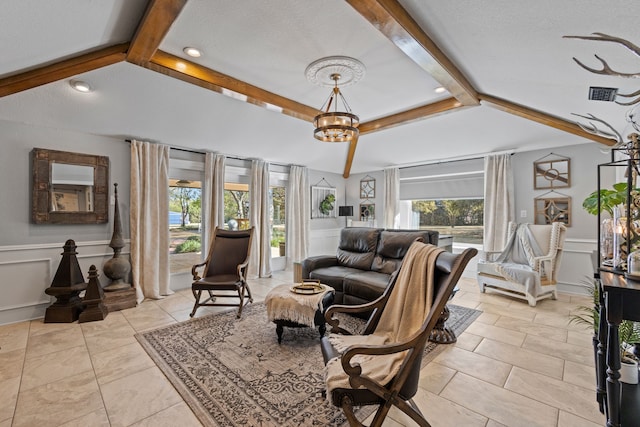 living room with a notable chandelier, a healthy amount of sunlight, a textured ceiling, and vaulted ceiling with beams