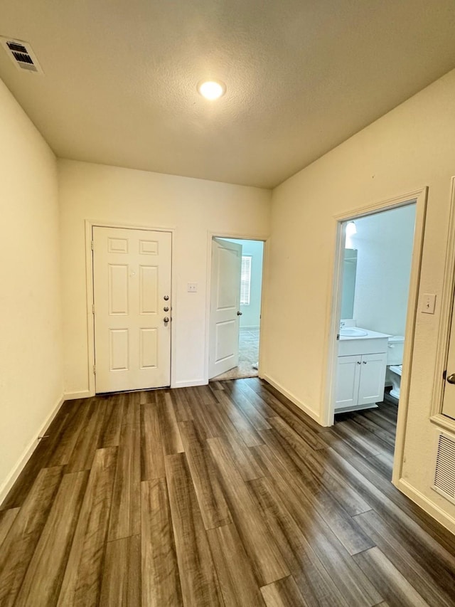 720 Juniper St, Anna, TX 75409 - empty room with dark wood-type flooring, a sink, baseboards, and a textured ceiling