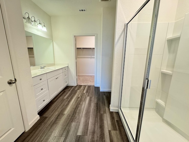 720 Juniper St, Anna, TX 75409 - bathroom with wood finished floors, a shower stall, vanity, a walk in closet, and baseboards