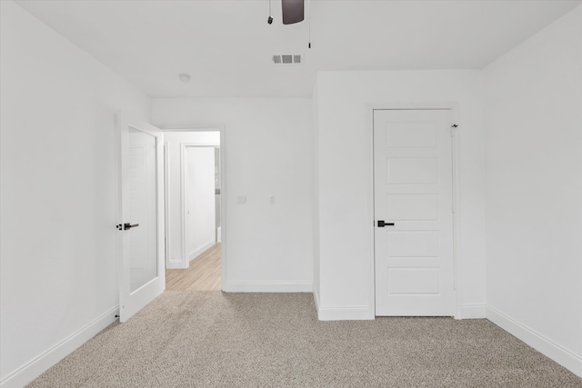 unfurnished room with ceiling fan and light colored carpet