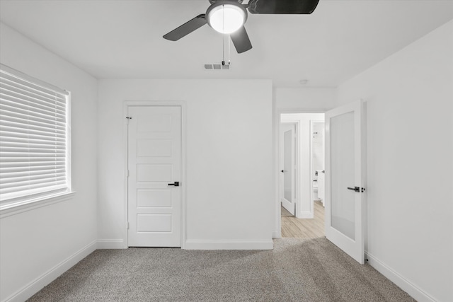 unfurnished bedroom featuring ceiling fan, a closet, and light carpet