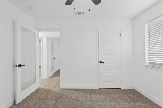 unfurnished bedroom featuring light carpet, a closet, and ceiling fan