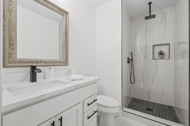 bathroom with a tile shower, vanity, and toilet