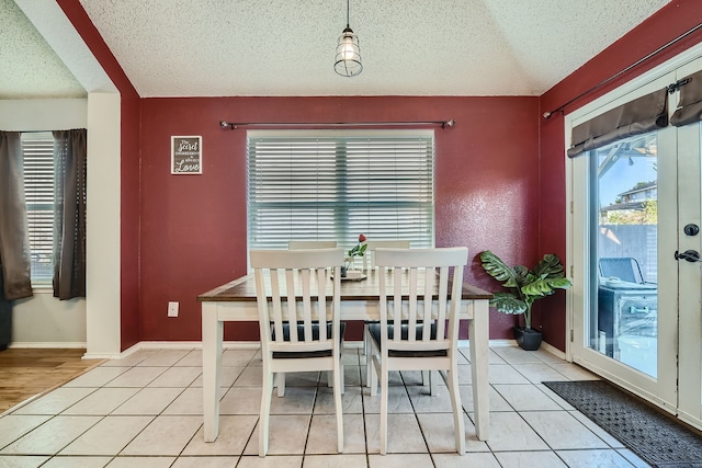 tiled dining area featuring a textured ceiling