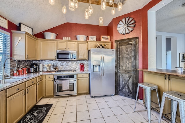 kitchen with sink, a textured ceiling, stainless steel appliances, lofted ceiling, and decorative light fixtures