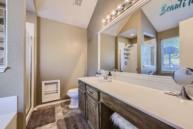 bathroom with a textured ceiling, toilet, walk in shower, lofted ceiling, and vanity