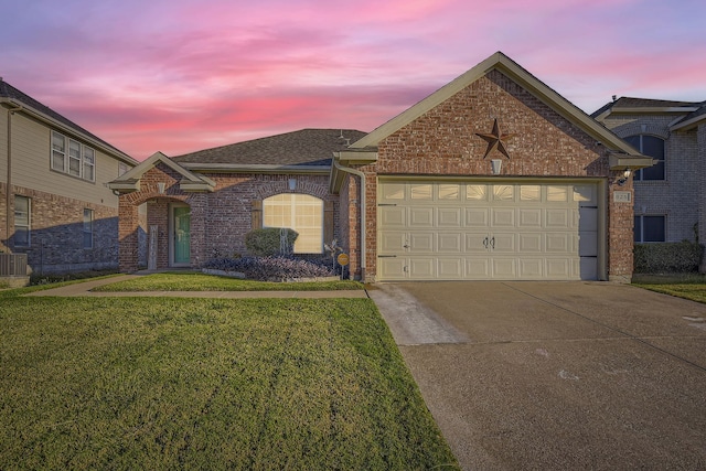 view of front of property featuring a garage and a lawn