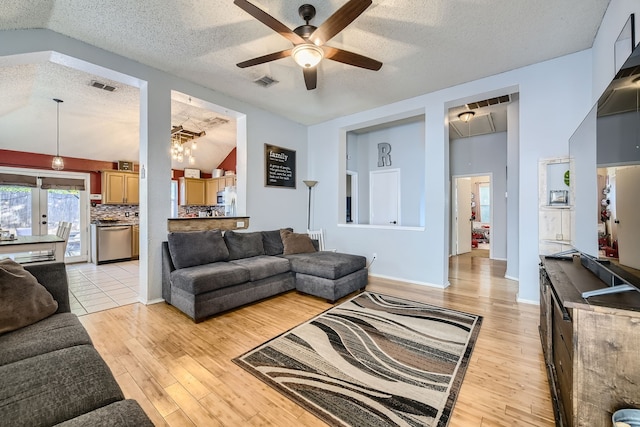 living room featuring lofted ceiling, a textured ceiling, light hardwood / wood-style floors, and ceiling fan