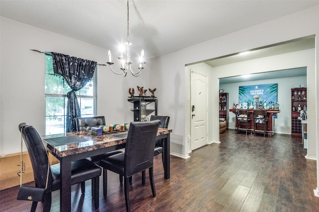 dining area with dark hardwood / wood-style flooring and a chandelier