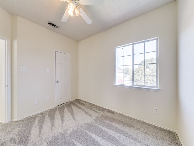 unfurnished room with ceiling fan, carpet, and a textured ceiling