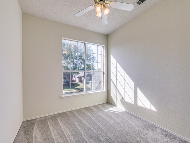 spare room with a textured ceiling, carpet flooring, and ceiling fan