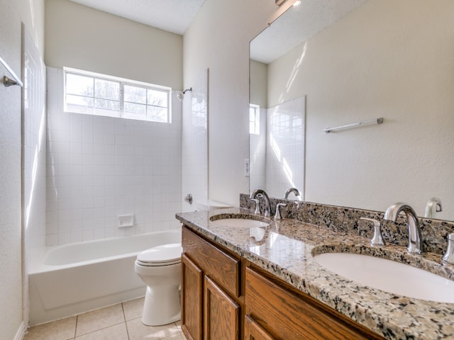 full bathroom featuring toilet, tiled shower / bath, vanity, and tile patterned flooring