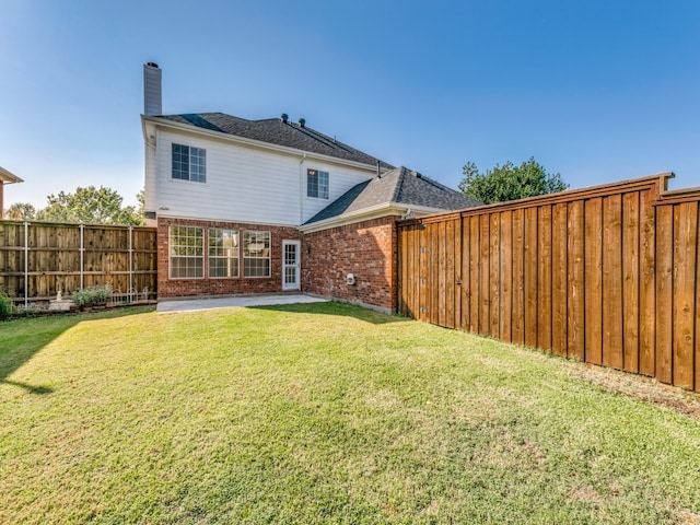 back of property with a patio area and a lawn