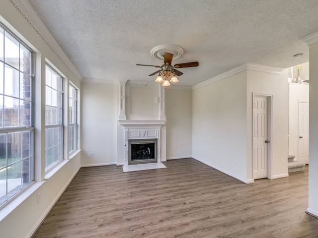 unfurnished living room with crown molding, hardwood / wood-style floors, a textured ceiling, and ceiling fan