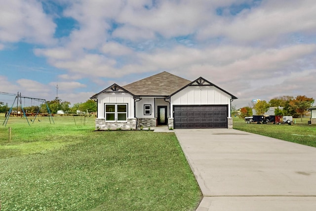 view of front facade featuring a front yard, a playground, and a garage