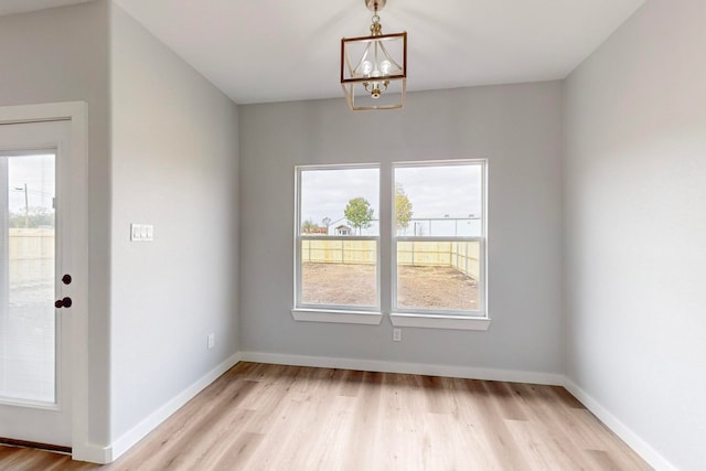 interior space with a notable chandelier, light wood-type flooring, and plenty of natural light