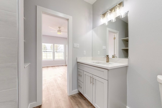 bathroom with vanity, wood-type flooring, toilet, and ceiling fan