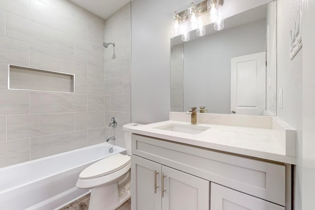 full bathroom with vanity, tiled shower / bath combo, and toilet