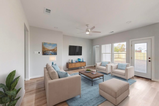 living room with light hardwood / wood-style floors and ceiling fan