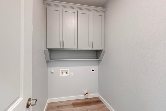 laundry area with cabinets, gas dryer hookup, hookup for a washing machine, light hardwood / wood-style floors, and hookup for an electric dryer