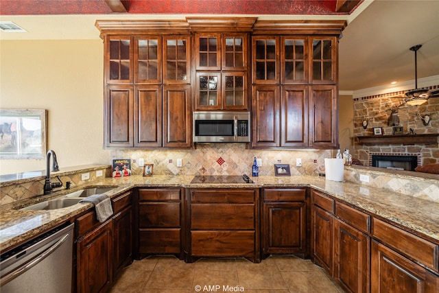 kitchen with backsplash, sink, a fireplace, crown molding, and stainless steel appliances