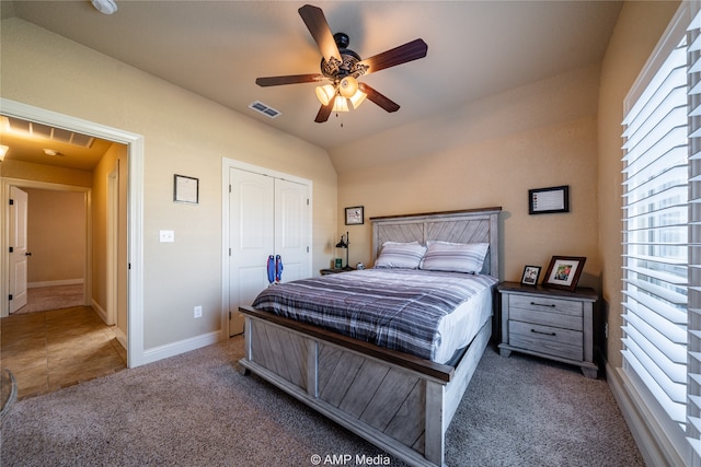 carpeted bedroom with a closet, ceiling fan, and vaulted ceiling