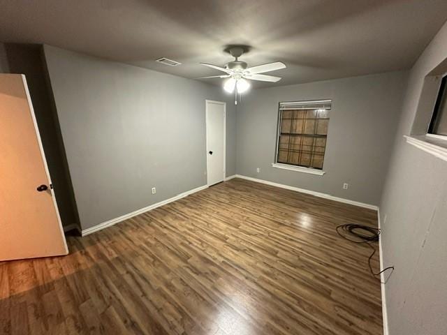 spare room with ceiling fan and dark hardwood / wood-style floors