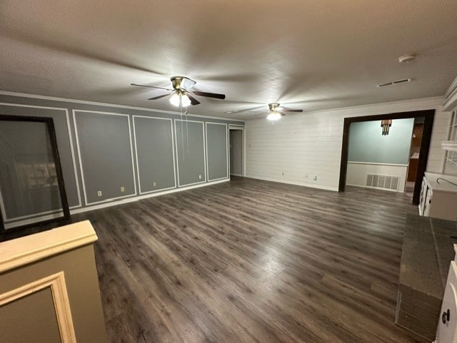 unfurnished living room with dark hardwood / wood-style floors and ornamental molding